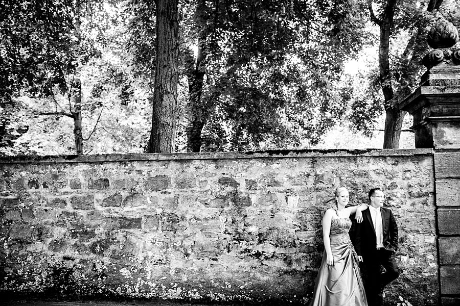 Braut und Bräutigam stehen an einer Wand