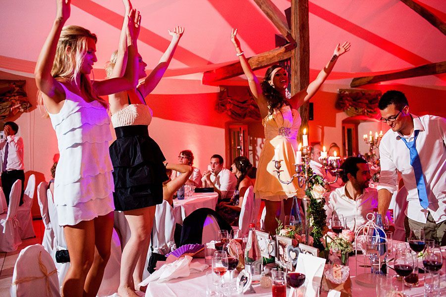Partygäste tanzen im Schloss auf den Stühlen Hochzeit