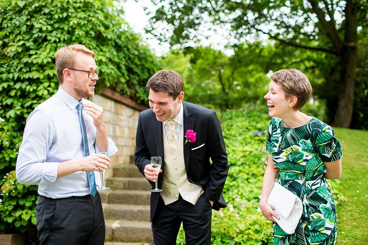 Gäste und Bräutigam lachen auf Hochzeit in Wiesbaden