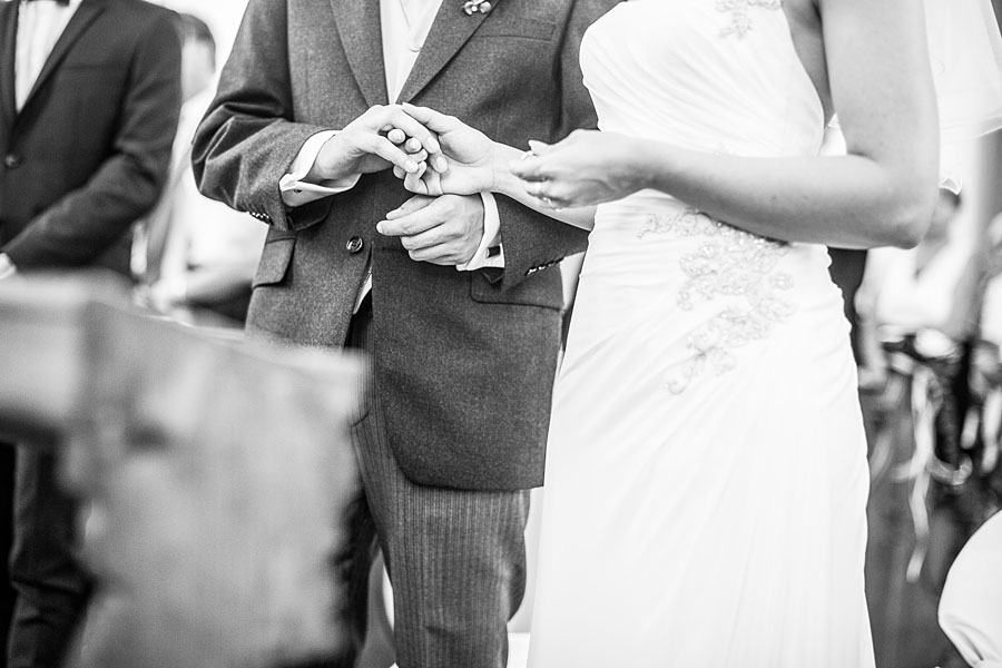 Bräutigam hält die Hand seiner Braut in der Kirche