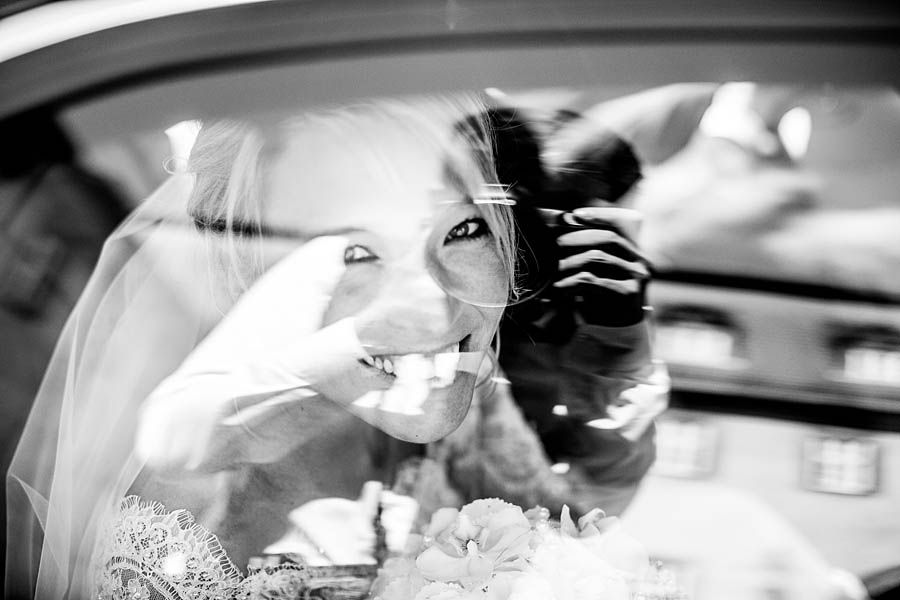 Braut lächelt aus dem Auto wunderhübsch