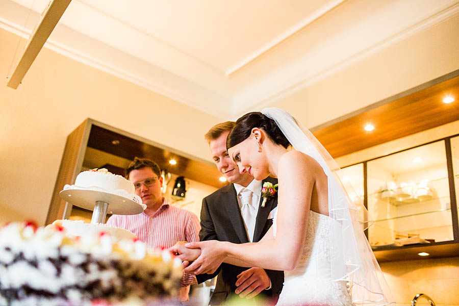 Hochzeitstorte wird angeschnitten im Schlosshotel