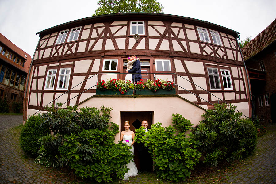 Braut, Bräutigam und Trauzeugen steht vor einem Haus
