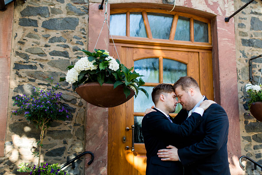 Schwules paar lächelt sich verliebt auf Hochzeit an