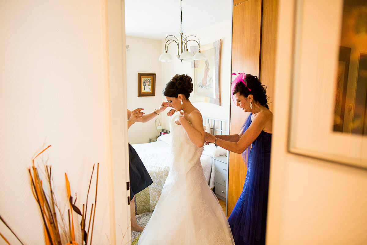 Braut zieht Brautkleid kurz vor der Trauung an