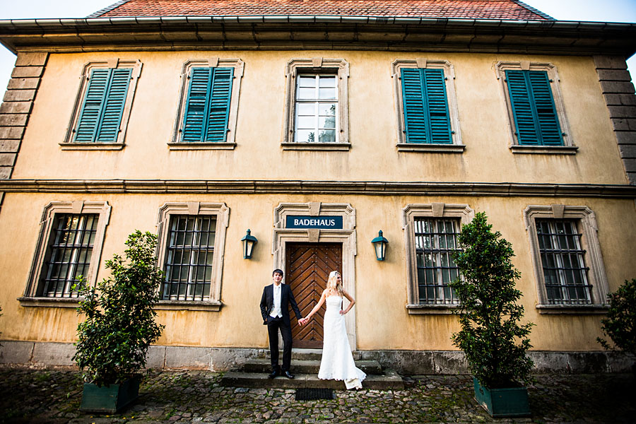 Brautpaar steht vor Badehaus in Schloss Fasanerie