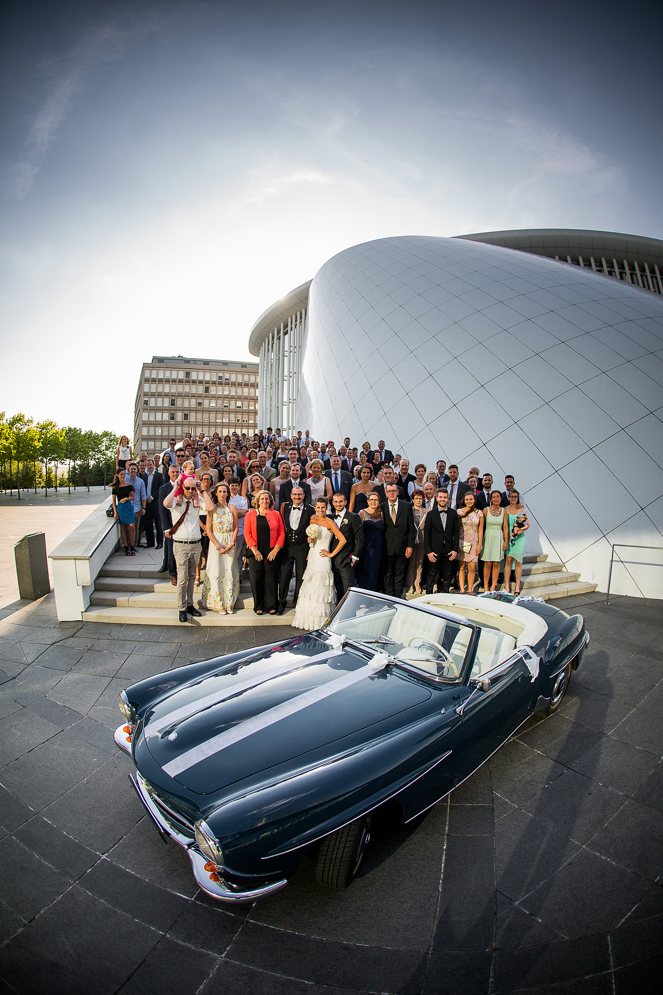 Philharmonie Hochzeit Gruppenfoto Luxemburg, Gruppenfoto mit Auto, Hochzeitsauto, Mercedes benz, Dreamwedding, Hochzeitspaar, Sonnenuntergang, Philharmonie, happy, Hochzeitsgäste