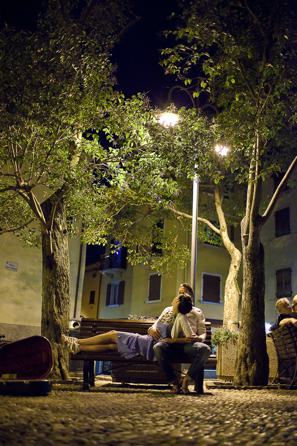 Brautpaar sitzt bei nacht in Malcesine und küsst sich
