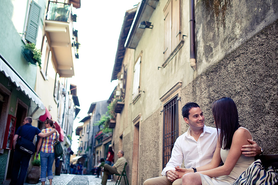 Paar sitzt im Ort Malcesine und lächelt